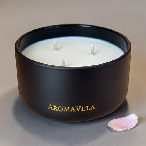 Black candle with 'Aromavela' branding on a neutral background